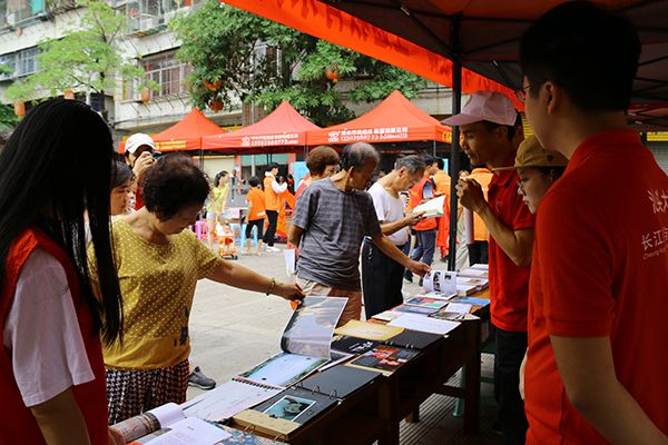 （社区居民翻阅公司《公益摄影—乡土潮汕百村行》课程的优秀作品）