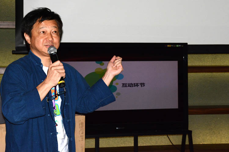 （报道团指导老师加藤隆则在跟员工们互动 伍颖欣/摄）
