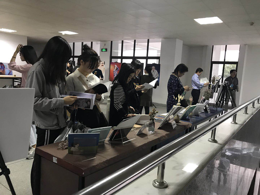 （员工正在作品展上翻看作品 卢星霏摄） 